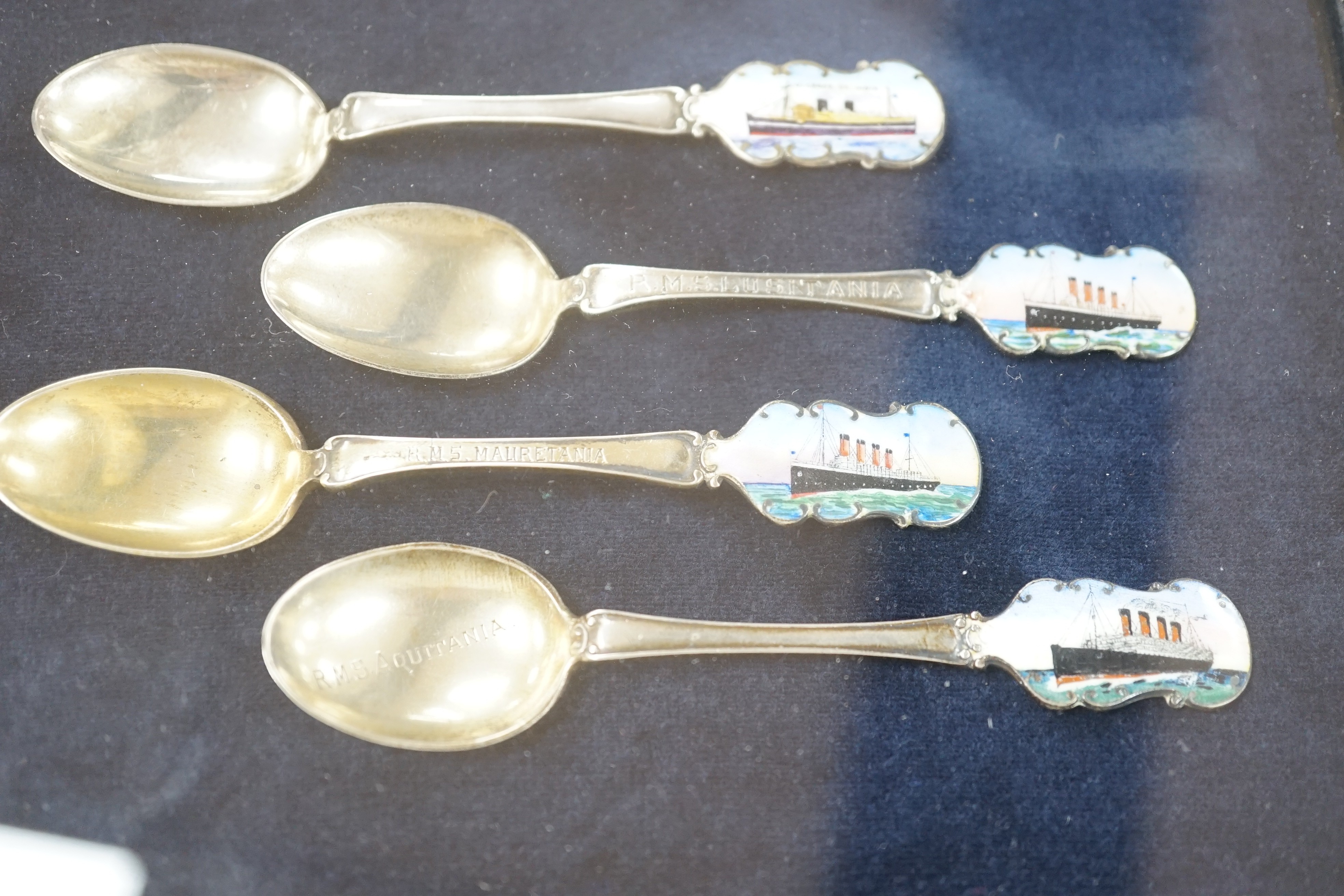 Cunard and P&O liners interest - four early 20th century silver and enamel souvenir spoons, inscribed RMS Lusitania, RMS Aquitania, RMS Mauretania and Viceroy of India, cased